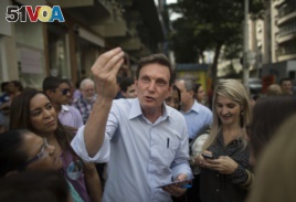 FILE - In this Sept. 29, 2014 file photo, retired Pentecostal Bishop Marcelo Crivella campaigns for the governorship of Rio de Janeiro state in Brazil's Copacabana. Amid reports that a play with a transgender Jesus might go to Rio de Janeiro's Museum