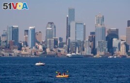 Kayakers and boaters ply the waters of Elliott Bay with the Seattle skyline behind during a heat wave hitting the Pacific Northwest, Sunday, June 27, 2021. (AP Photo/John Froschauer)