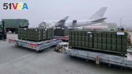 Workers and Ukrainian servicemen unload a shipment of ammunition delivered as part of U.S. security assistance to Ukraine, at the Boryspil International Airport outside Kyiv, Ukraine November 14, 2021. (Press service of the U.S. Embassy in Ukraine/Handout