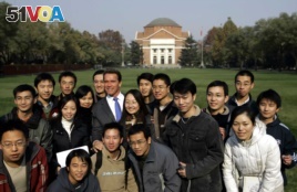 FILE - Former California Gov. Arnold Schwarzenegger poses for a group photo with students during a visit to Tsinghua University in Beijing Wednesday Nov. 16, 2005.