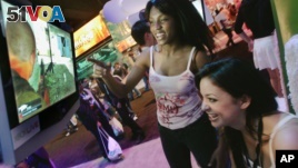 Members of the PMS Clan, a group of professional women gamers, Alexis Hebert, seated, and Felicia Williams play an X-Box game titled 