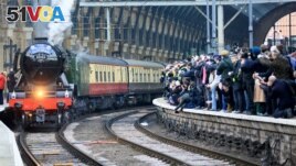 FILE - People watch from a railway platform as the Flying Scotsman steam engine prepares to leave Kings Cross station in London, February 25, 2016. (REUTERS/Paul Hackett/File)