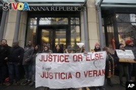 Protesters block an entrance to Banana Republic store on Friday, Nov. 27, 2015, in Chicago as community activists and labor leaders hold a demonstration responding to the release of a video showing an officer fatally shooting Laquan McDonald. (AP Photo/Nam Y. Huh)