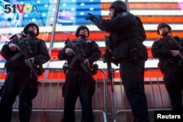 Armed New York City police officers with the special operation division Strategic Response Group stand guard in Times Square in New York, as security was tightened following the deadly attacks in Paris, Nov. 14, 2015.