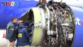 National Transportation Safety Board investigators examine damage to the engine of the Southwest Airlines plane that made an emergency landing at Philadelphia International Airport in Philadelphia, April 17, 2018. (NTSB via AP) 