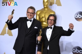 Adam McKay, left, and Charles Randolph pose with the award for best adapted screenplay for 