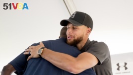 Golden State Warriors guard Stephen Curry, right, hugs Howard University President Wayne Frederick, left, during a news conference at Langston Golf Course in Washington, Monday, Aug. 19, 2019, where Curry announced that he would be sponsoring the creation