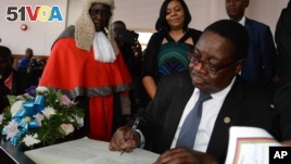 Newly elected Malawian president Peter Mutharika signs the oath book after he was sworn in, at the High Court in Blantyre, Malawi, May 31, 2014.