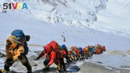 In this May 22, 2019 photo, a long queue of mountain climbers line a path on Mount Everest just below camp four, in Nepal. 