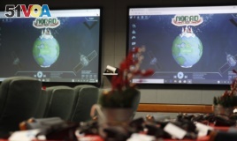 FILE - Monitors are illuminated in the NORAD Tracks Santa center at Peterson Air Force Base, Monday, Dec. 23, 2019, in Colorado Springs, Colo.