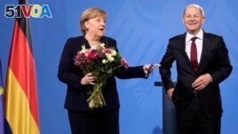 New elected German Chancellor Olaf Scholz, right, has given flowers to former Chancellor Angela Merkel during a handover ceremony in the chancellery in Berlin, Wednesday, Dec. 8, 2021. (Photo/Markus Schreiber)