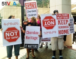 File photo shows Cherokee tribe members protesting the adoption of a 3-year-old Cherokee girl by a non-Native couple, Wednesday, Aug. 14, 2013 in Tulsa, OK.