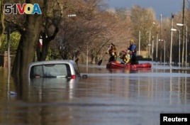 Rescue workers remove local residents by boat from a flooded residential street in Carlisle, Britain December 6, 2015.