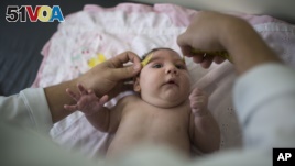 In this Dec. 22, 2015 photo, Luiza has her head measured by a neurologist at a hospital in Brazil's Pernambuco state. Her rare condition, known as microcephaly, could be caused by the Zika virus. Microcephaly often results in mental retardation. (AP Photo/Felipe Dana)