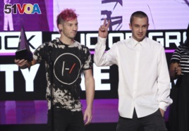 Josh Dun, left, and Tyler Joseph, of Twenty One Pilots, accept the award for favorite duo or group - pop/rock at the American Music Awards at the Microsoft Theater on Nov. 20, 2016, in Los Angeles.