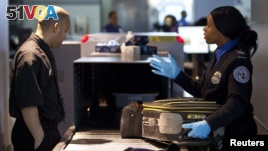 In this 2012 file photo, a Transportation Security Administration (TSA) security agent checks a traveler's luggage at John F. Kennedy Airport in New York. (REUTERS/Andrew Burton)