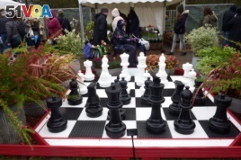 Chess set pieces are displayed along with flowers on a stand at the RHS Cardiff Flower Show, Cardiff, Wales, April 15, 2018.