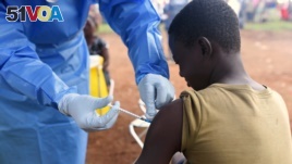 A Congolese health worker administers Ebola vaccine to a boy who had contact with an Ebola sufferer in the village of Mangina in North Kivu province of the Democratic Republic of Congo, August 18, 2018. (REUTERS/Olivia Acland)