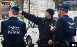 Belgian police secure an area during a search in Etterbeek, Brussels, Belgium, April 9, 2016. Police raids continue following the Brussels bombings on March 22 where at least 31 people were killed and hundreds injured in bomb explosions.