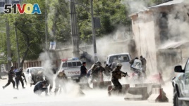 Security forces run from the site of a suicide attack after the second bombing in Kabul, Afghanistan, Monday, April 30, 2018. 