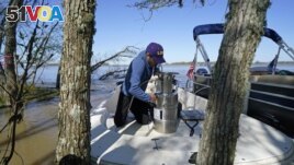 Andre Rabay, research scientist for the LSU Department of Oceanography and Coastal Science, prepares a canister of liquid nitrogen that he will use to freeze samples of the ground on Mike Island, part of the Wax Lake Delta in the Atchafalaya Basin, in St.