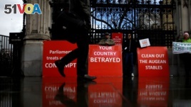 FILE - A person walks past pro-Brexit protesters outside the Houses of Parliament, April 4, 2019. 