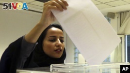 A Saudi woman casts her ballot at a polling center during municipal elections in Riyadh, Saudi Arabia, Dec. 12, 2015.