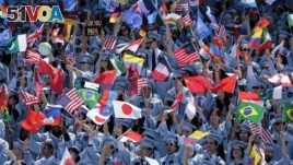 Graduating students from the School of International and Public Affairs at Columbia University wave flags during a graduation ceremony in New York, Wednesday, May 17, 2017.