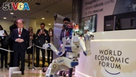 Technologies like robotics are seen as a driver of the so-called Fourth Industrial Revolution. HUBO, a walking humanoid robot performs a demonstration of its capacities next to its developer Oh Jun-Ho during the annual meeting of the World Economic Forum.