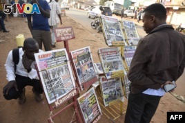 People gather around a newspaper stand to read the local daily papers on Feb. 17, 2016 ahead of tomorrow's presidential elections.