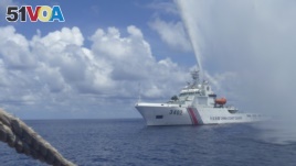 Chinese Coast Guard members approach Filipino fishermen as they confront each other off Scarborough Shoal in the South China Sea, also called the West Philippine Sea, Sept. 23, 2015.