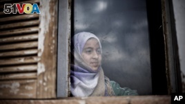 A Syrian girl from Aleppo looks outside a window of an abandoned building where her and several families took refuge due to fighting between Free Syrian Army fighters and government forces in the northeastern city of Qamishli, Syria, Thursday, Feb. 28, 2013. (AP Photo/Manu Brabo)