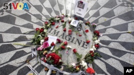 Flowers adorn the Imagine mosaic in remembrance of John Lennon, in the Strawberry Fields section of New York's Central Park, Tuesday, Dec. 8, 2015. Thirty-five years ago, Mark David Chapman shot and killed the former the Beatle.  (AP Photo/Richard Drew)