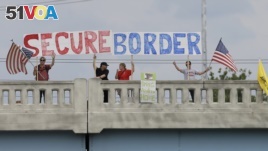 FILE - Demonstrators with signs on an overpass in Indianapolis, Indiana, protest against people who immigrate illegally July 18, 2014.