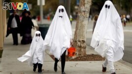 FILE - On Halloween, a family of ghosts walk in a neighborhood in Sierra Madre, California, U.S., on October 31, 2017. (REUTERS/Mario Anzuoni)
