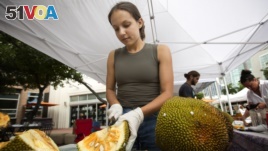 Sara Diaz, from LNB Groves, cuts a jackfruit at the Monday night green market in downtown Miami, Monday, June 8, 2015. (AP Photo/J Pat Carter)