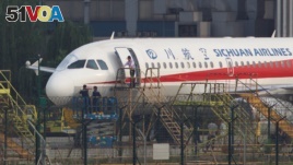 Workers inspect a Sichuan Airlines aircraft that made an emergency landing after a windshield on the cockpit broke off, at an airport in Chengdu, Sichuan province, China May 14, 2018. Picture taken May 14, 2018. REUTERS/Stringer
