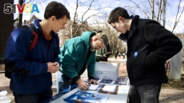 In this March 20, 2008, photo young student Obama volunteers Mike Stratta, left, and Christo Logan, right, stand with University of Pennsylvania employee Dave Munson, 45, as he fills up a voter registration form on University of Pennsylvania campus, in Philadelphia. (AP Photo)