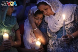 In this Monday, August 6, 2012 file photo, Sikh worshipers gather for a candlelight vigil after prayer services at the Sikh Religious Society of Wisconsin in Brookfield, Wisconsin.