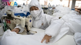 Workers sew hazardous material suits to be used in the COVID-19 outbreak at the Zhejiang Ugly Duck Industry garment factory in Wenzhou, China. (Photo by NOEL CELIS / AFP)