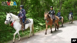 Rescuers on horseback search for a 7-year-old boy who is missing in a Japanese forest in northern Japan. He has been missing since late Saturday afternoon after his parents reportedly made him get out of the car as punishment. (Ichinoshin Matsuhashi/Kyodo News via AP