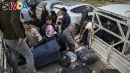 Syrians put their belongings into vehicles after crossing into Turkey at the Cilvegozu border gate with Syria, near Hatay, southeastern Turkey, Dec. 18, 2016.
