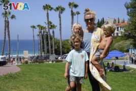 Hillary Salway poses for a photo with her children - Dane Salway, 5, Mick Salway, 1, and Beaux Salway, 3 - on Monday, July 13, 2020, in San Clemente, Calif. Salway plans to send her children back to school in the fall.