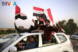 Iraqis wave national flags, celebrating the anniversary of the victory over the Islamic State group, in the so-called Green Zone in Baghdad, Iraq, Monday, Dec. 10, 2018. (AP Photo/Karim Kadim)