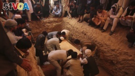 Afghans bury the bodies of victims of the Dubai City wedding hall bombing during a mass funeral in Kabul, Afghanistan, Sunday, Aug.18, 2019. (AP Photo/Rafiq Maqbool)