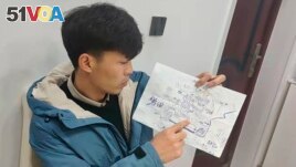 Li Jingwei points to a detail a map he drew from memory of his childhood village as he sits in Lankao in central China's Henan Province, Jan. 5, 2022. Abducted by child traffickers when he was 4 years old, Li was able to find his mother some 30 years later. (Li Jingwei via AP)