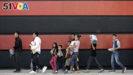 Immigrant families walk along a sidewalk on their way to a respite center after they were processed and released by U.S. Customs and Border Protection, Sunday, June 24, 2018, in McAllen, Texas. (AP Photo/David J. Phillip)