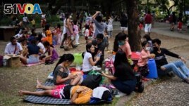 Parents and children relax at a public park, as the country's capital region loosens coronavirus disease (COVID-19) restrictions, in Quezon City, Metro Manila, Philippines, November 2, 2021. (REUTERS/Lisa Marie David)