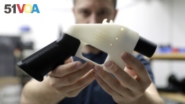 Cody Wilson holds a 3D-printed gun at his shop in Austin, Texas, Aug. 1, 2018.