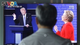 A man watches a TV screen showing the live broadcast of the U.S. presidential debate in Seoul.